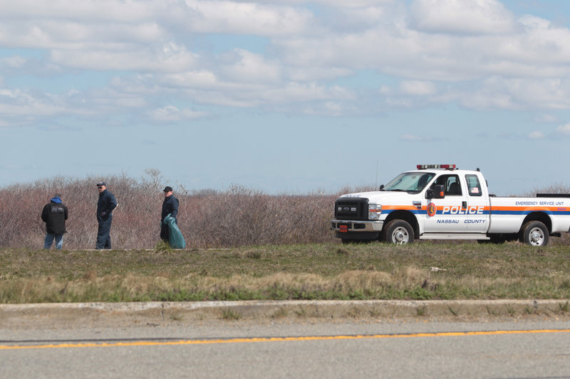 Police officers search for possible victims of a suspected serial killer along Ocean Parkway near Cedar Beach, N.Y., last month.