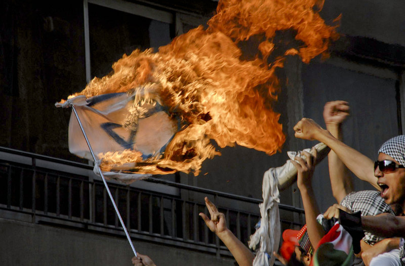 Demonstrators burn an Israeli flag near the Israeli embassy in Cairo, Egypt, on Sunday. Israeli troops clashed with Arab protesters along three hostile borders, leaving 15 people dead in an unprecedented wave of demonstrations marking the Palestinian “nakba,” or “catastrophe,” a day of mourning for their defeat at Israel’s hands in 1948.