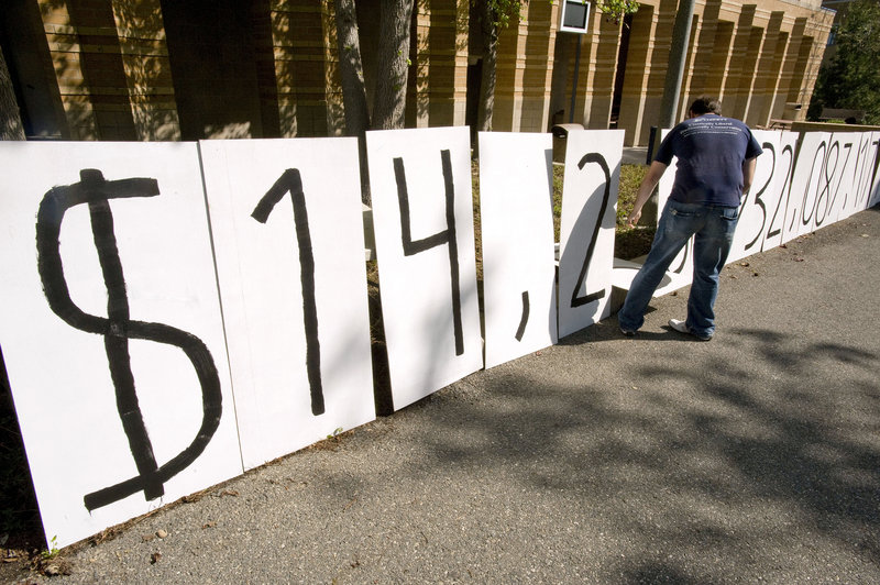 Adam Weinberg, a member of Young Americans for Liberty, resets numbers on a national debt clock in Irvine,Calif., in April. If Congress doesn’t end its standoff and raise the debt ceiling beyond $14.3 trillion, the govern-ment could default. “In the economic area, this is the equivalent of nuclear war,” says analyst Edward Knight.