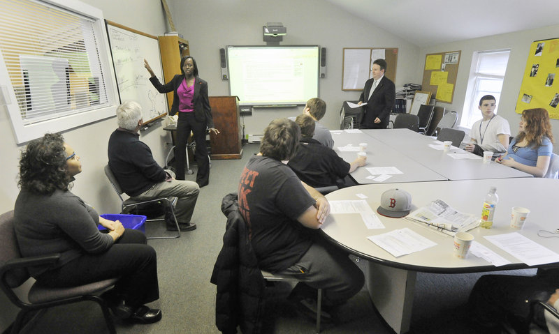 Bank employee Carine Rugema Stubbs teaches financial literacy classes at Youth Building Alternatives, operated by Learning Works in Portland, on Tuesday. "She's able to connect with them and make topics relevant with them," said Bodi Luse, a Learning Works spokeswoman.