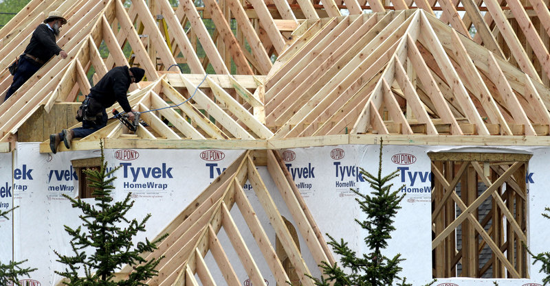 Two workers install roof joists on a new home in Pepper Pike, Ohio. Single-family home building has dropped 11 percent in the last two years.