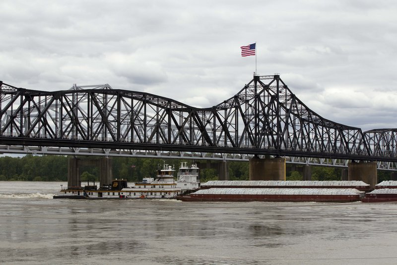 Several boats push cargo barges up the Mississippi River in Vicksburg, Miss., on Monday. The Coast Guard reopened the swollen Mississippi River north of New Orleans on Tuesday.