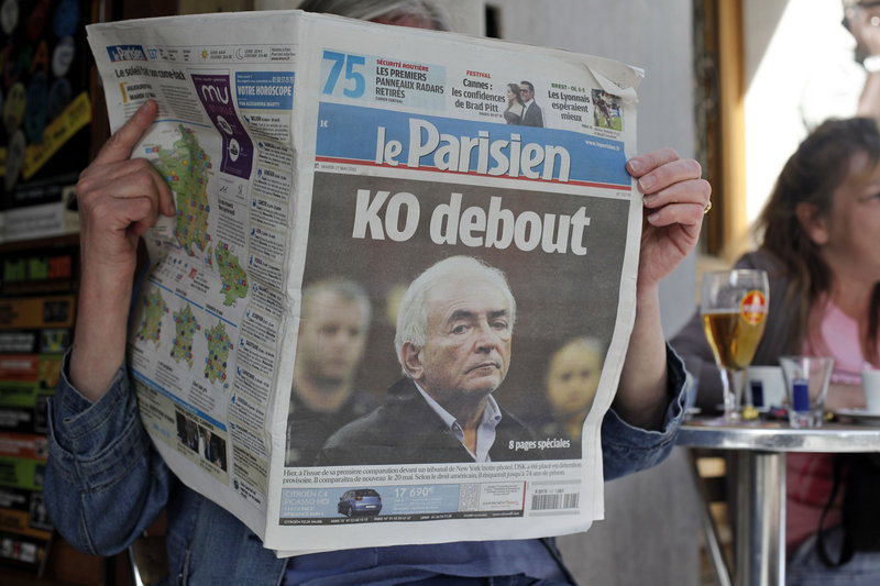 A woman reads the French newspaper Le Parisien, with a headline about the arrest on sexual assault charges of Dominique Strauss-Kahn, the head of the International Monetary Fund, in Paris on Tuesday. Strauss-Kahn had been considered a possible contender for French president.