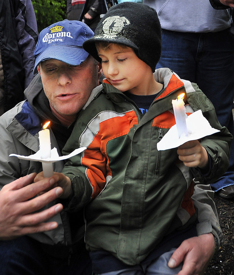 Jay Wilcox of Sanford and his son, Travis, 7, were among about 400 people who attended a South Berwick vigil Tuesday for an unidentified boy whose body was found in the woods there.