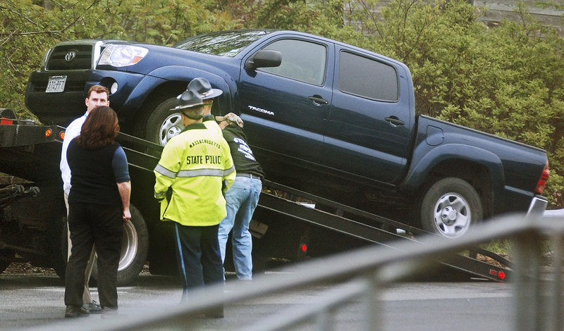 Massachusetts State Police officers stand by Wednesday as a Toyota Tacoma driven by Julianne McCrery is placed on a tow truck in a rest area along I-495 in Chelmsford, Mass.