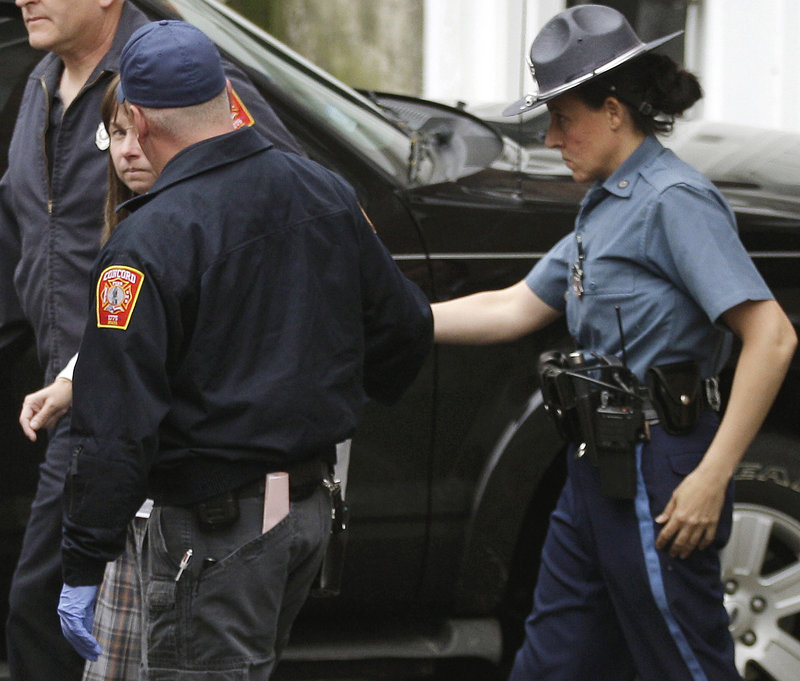 Julianne McCrery, 42, of Texas is escorted by emergency and law enforcement authorities from the Massachusetts State Police barracks in Concord, Mass.. She reportedly was taken into custody Wednesday morning at a rest area along Interstate 495 in Chelmsford, Mass.