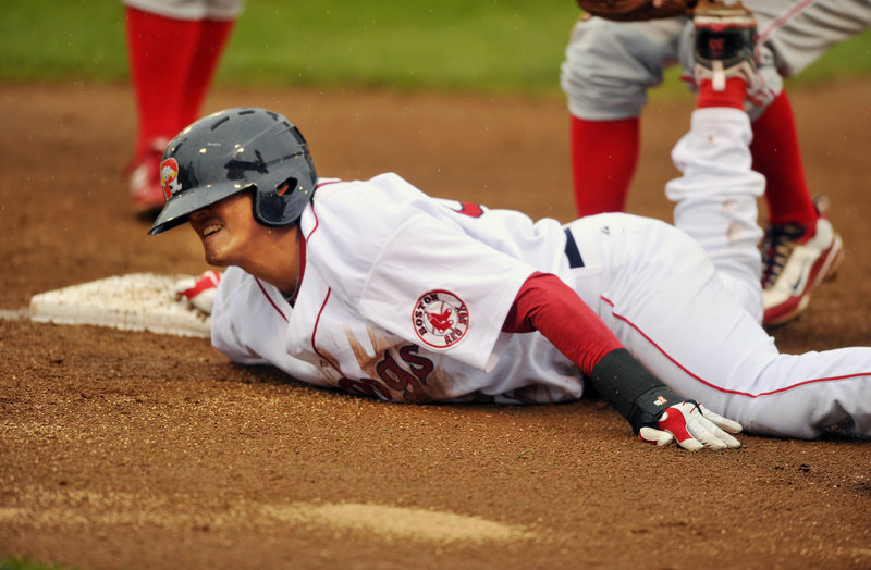 Che-Hsuan Lin dives safely back to first base Wednesday night at Hadlock Field during the Sea Dogs’ 13-4 loss against the Reading Phillies.