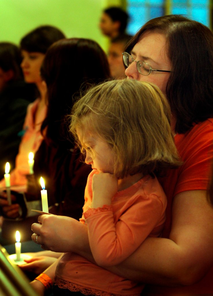 Elita Galvin and her daughter Sarah, 4, attend the vigil at First Parish Federated Church in South Berwick on Wednesday held for Camden Pierce Hughes, whose body was found in South Berwick on Saturday.