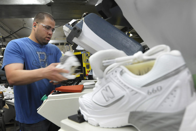 Justin Waring places soles on shoes at the New Balance plant in Norridgewock.