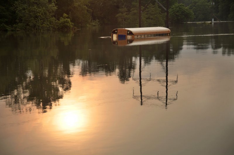 An old school bus sits in floodwaters from the rising Mississippi River in St. Francisville, La., where a dozen homes and businesses, and several camps were flooded Friday. A mandatory evacuation starts today.