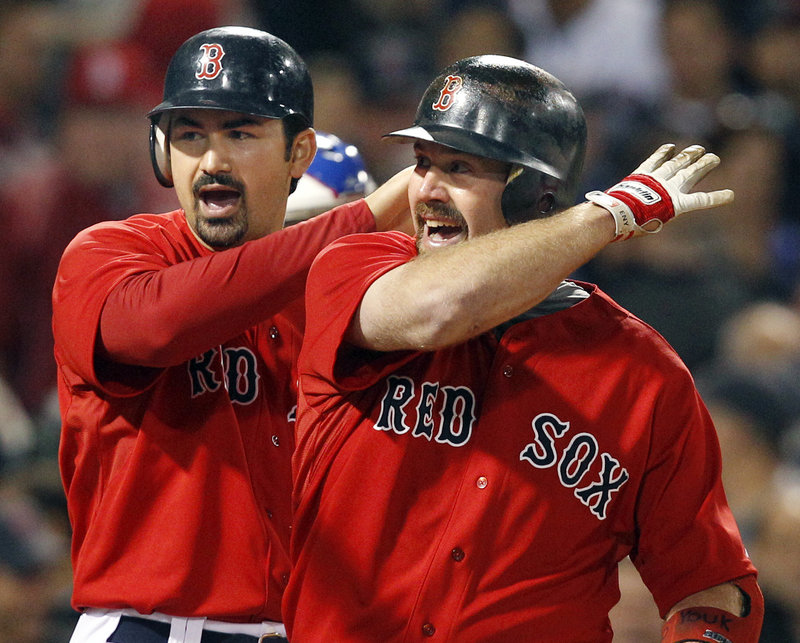 Adrian Gonzalez, left, and Kevin Youkilis celebrate Youkilis’ two-run homer in the fourth inning Friday night. The Red Sox rolled up 19 hits in a 15-5 win over Chicago.