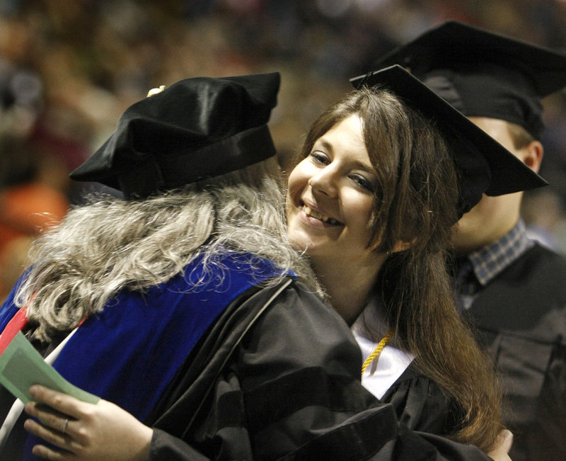 Graduate Alexandra-Elna Panaitiu hugs Linda Morrison, faculty marshal and chair and associate professor of psychology.