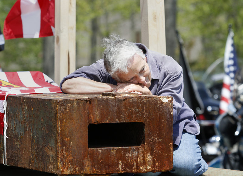 Sue Millman of Portland, Ore., a retired Army Reserve nurse, spends a moment in quiet meditation with one of the World Trade Center beams transported from New York City to Freeport on Saturday for use in a Sept. 11 memorial.