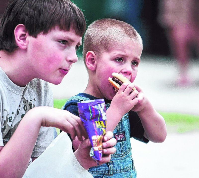 Teigan Cole, 9, and his cousin Isaiah Cole, 4, take a break from the activities for lunch.
