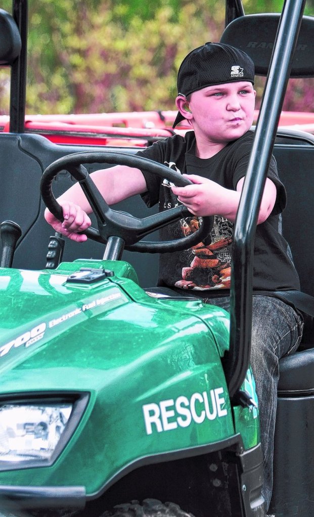 Dakotah Staples, 8, gets comfortable behind the wheel of an emergency medical services four-wheeler.