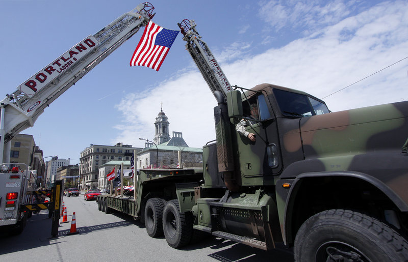 Staff Sgt. Robert Martel of Lisbon peers out of the truck carrying the beam as the convoy journeys past the Portland Fire Department on Congress Street on Saturday.