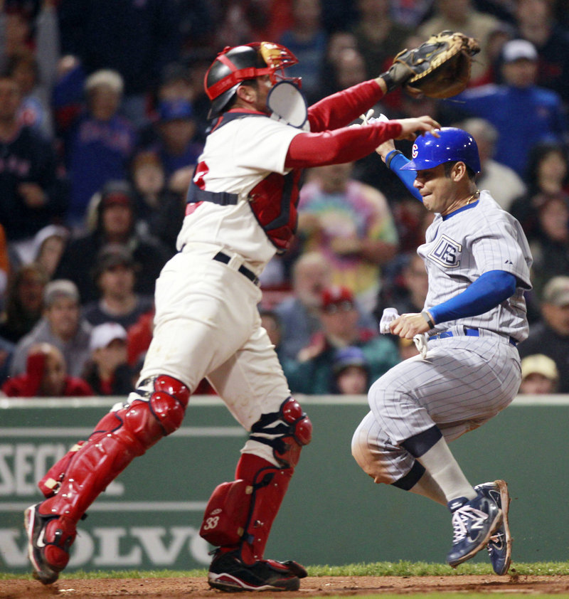 Red Sox catcher Jason Varitek reaches for a throw Saturday night as Carlos Pena crosses the plate for the Chicago Cubs after shortstop Jed Lowrie dropped a pop fly. It was all part of a horror-filled eighth inning that doomed Boston to a 9-3 loss at Fenway Park.