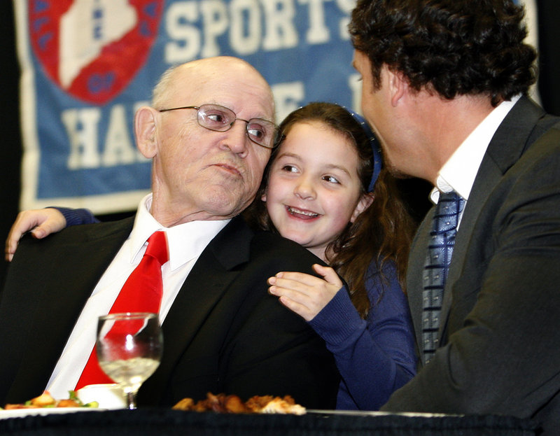 Harold "Tank" Violette receives a hug from his granddaughter, Allison Hegarty, 6, after getting an autograph from fellow Maine Sports Hall of Fame inductee Seth Wescott.