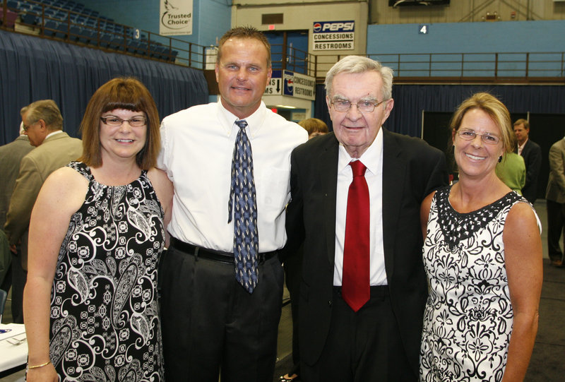 Dick McGee, honored for a long career as a football player, coach and athletic director, is joined by his daughters, Susan Perkins, left, and Marcia Goodhue, and his son, Mike, a longtime boys' basketball coach at Lawrence High.
