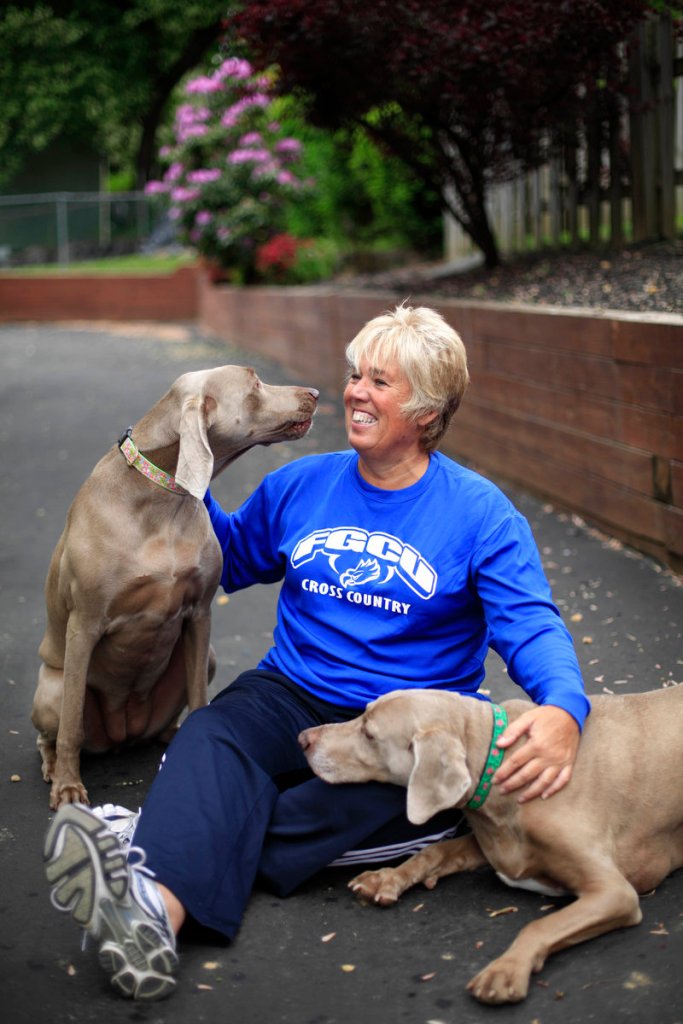 Karen Cornwall, 55, plays with her dogs Bel, left, and Mac in front of her Havertown, Pa., home. Cornwall, a nurse who has played a slew of sports since childhood, had both knees replaced last year.