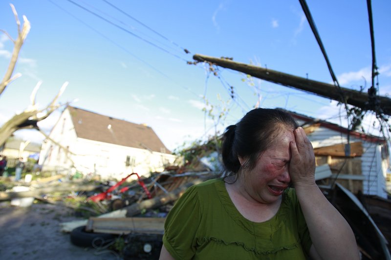 Chue Vang, 50, reacts after discovering that her Minneapolis home was damaged by a tornado Sunday.