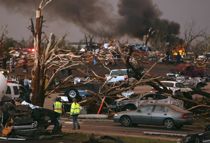 Emergency personnel walk through a neighborhood severely damaged by a tornado near the Joplin Regional Medical Center in Joplin, Mo., on Sunday. A large tornado damaged the hospital and hundreds of homes and businesses.