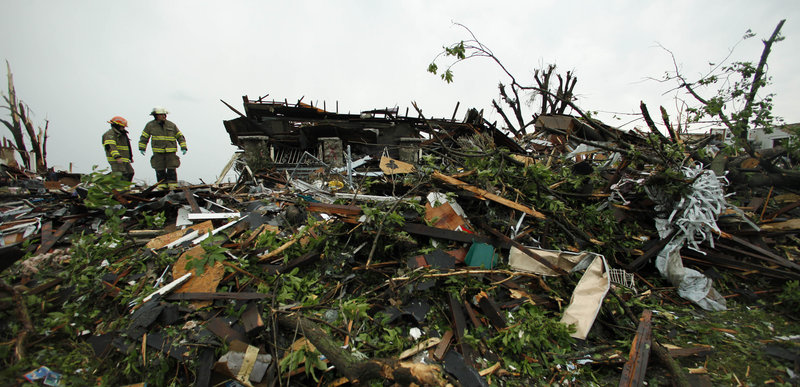 Firefighters on Monday search the rubble of a home destroyed by Sunday’s tornado in Joplin, Mo., that left at least 116 people dead.