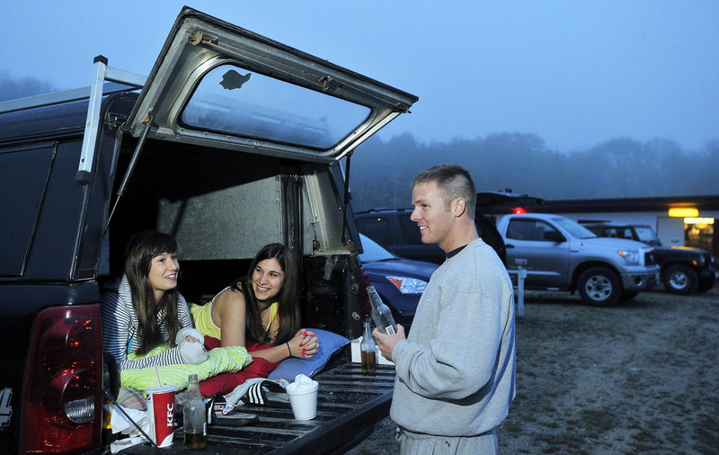 Jessica and Katlyn Irish of Windham chat comfortably with a friend, Chris Bennett of Gray, after settling in to watch a movie at the Prides Corner Drive-In on Route 302 in Westbrook. Prides Corner is one of five remaining drive-in theaters in Maine.