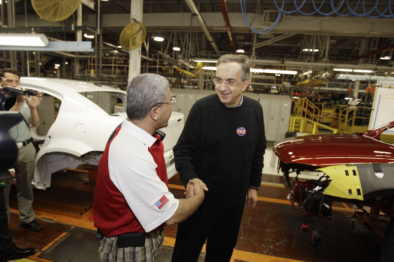 Chrysler Group CEO Sergio Marchionne, right, is greeted by Tony Al-Abawi on the assembly line Tuesday at the Sterling Heights Assembly Plant in Sterling Heights, Mich., where it was announced that the company had repaid $7.6 billion in loans.
