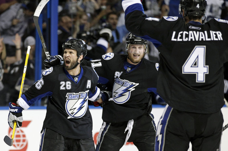 Martin St. Louis, left, celebrates with Steven Stamkos, center, and Vincent Lecavalier after scoring a second-period goal in Tampa Bay’s 5-4 win over the Bruins.