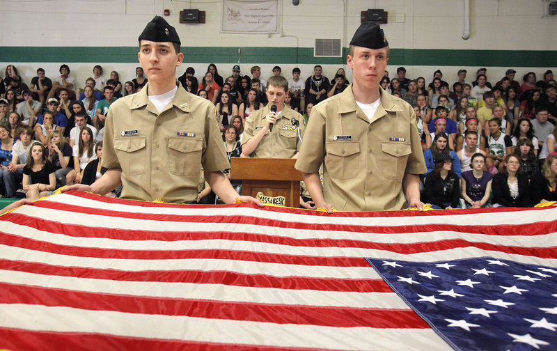 Tony Coburn, left, and Alex Storey perform a flag-folding ceremony Thursday with other Navy Junior Reserve Officer Training Corps cadets at Massabesic High School. Behind them is Daniel Mills, a NJROTC cadet who emceed the assembly.
