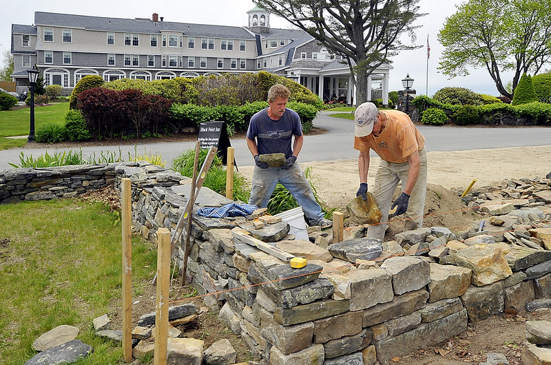 A stone wall takes shape Thursday at the Black Point Inn in Scarborough. Ted Wheeler, left, helps John Lord, owner of JS Lord Masonry of Naples, build the wall. The Memorial Day weekend is expected to be a busy period for the inn.