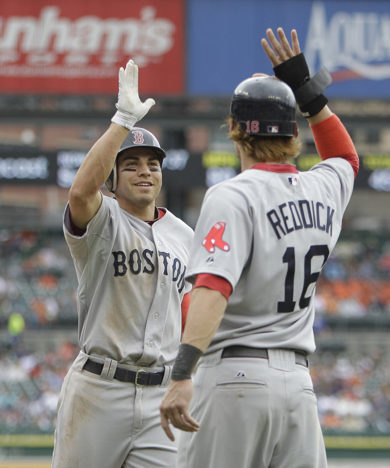 Jacoby Ellsbury, left, is greeted at home plate by Josh Reddick after hitting a three-run home run Thursday in the second inning of Boston’s 14-1 win over the Tigers at Detroit.