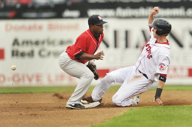 Jeremy Hazelbaker of the Portland Sea Dogs reaches second base with a steal as the ball skips past Callix Crabbe, the second baseman for the New Hampshire Fisher Cats.