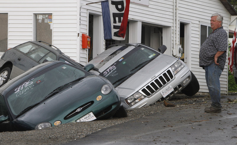 Rene Crete looks over damaged cars at Buy Right Auto in East Montpelier, Vt.