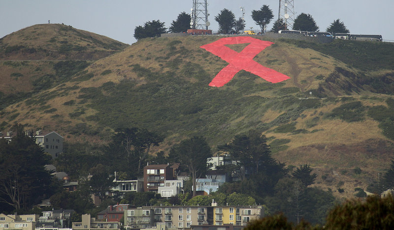 A giant red ribbon is seen atop Twin Peaks in San Francisco, placed there by community and civic leaders to mark the 30th anniversary next month of the first reported cases of AIDS. HIV prevention and caring for those with HIV are on the agenda at a Vatican symposium this weekend.