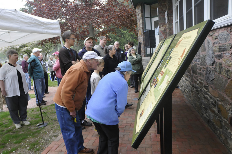 Visitors check out new informational signs that were unveiled at Evergreen Cemetery in Portland on Saturday by the Friends of Evergreen.