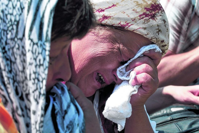 Bosnian Muslim women weep during a ceremony in Visegrad, Bosnia, to commemorate thousands of Bosnian Muslims killed by Serb troops commanded by Ratko Mladic at the start of Bosnia's 1992-95 war, on Saturday. Up to 2,000 Muslim Bosnians arrived on buses to throw about 3,000 roses into the Drina River, which divides Bosnia from Serbia. Mladic was arrested in Serbia on Thursday.