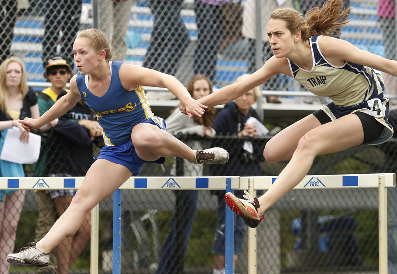 Carley O'Brien, right, of Traip Academy focuses on the finish and beats Doe Leckie of Lake Region in the 100-meter hurdles. O'Brien was named best in field events.