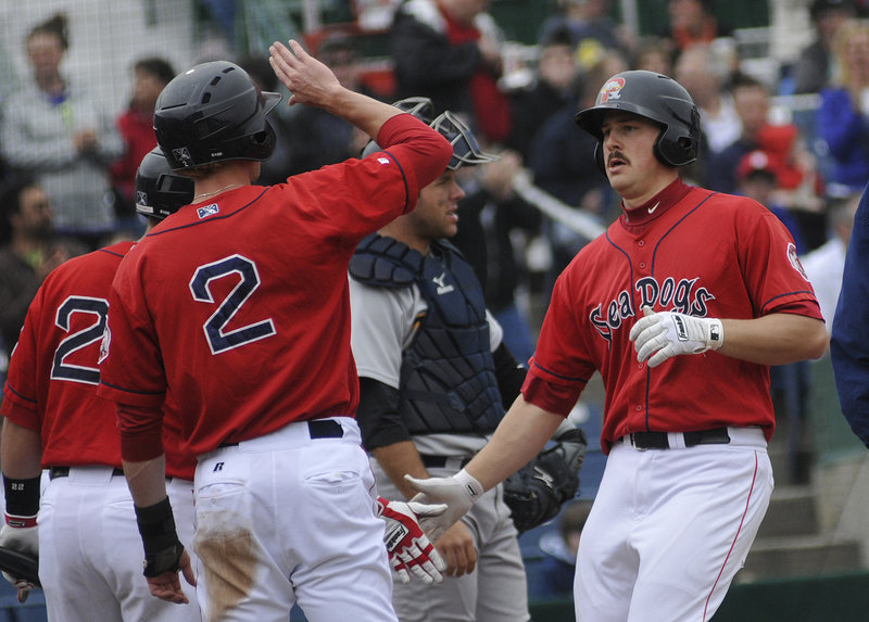 Ryan Lavarnway, right, is greeted at home plate after hitting the first of his two home runs in Portland s 8-7 loss to Trenton in the first game of a doubleheader Saturday at Hadlock Field. The Sea Dogs bounced back to win the second game, 7-5.