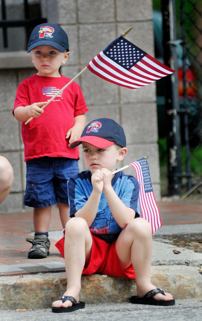 Reid Haile, 2, left, and Henry Haile, 5, of Westbrook show their patriotic spirit as they watch the Memorial Day parade in Portland on Monday.