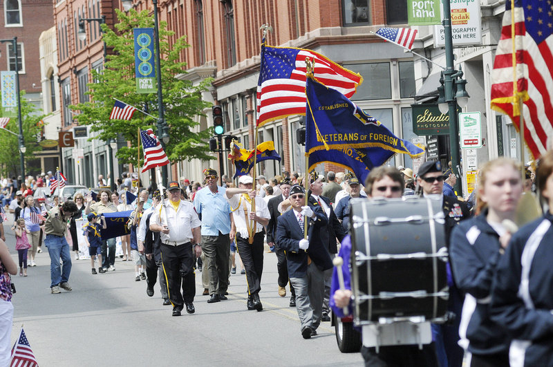 Veterans and marching bands parade down Congress Street in Portland on Monday.