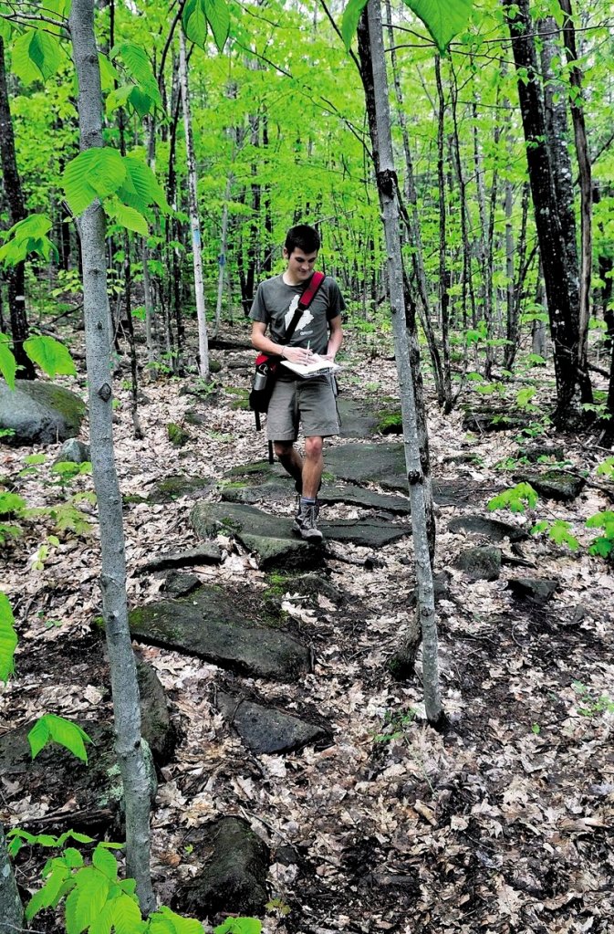Joel Alex, project coordinator for MaineTrailFinder.com, walks on a trail to Round Top Mountain in Rome. Alex is taking waypoints on a GPS unit to create a digital map of Maine.