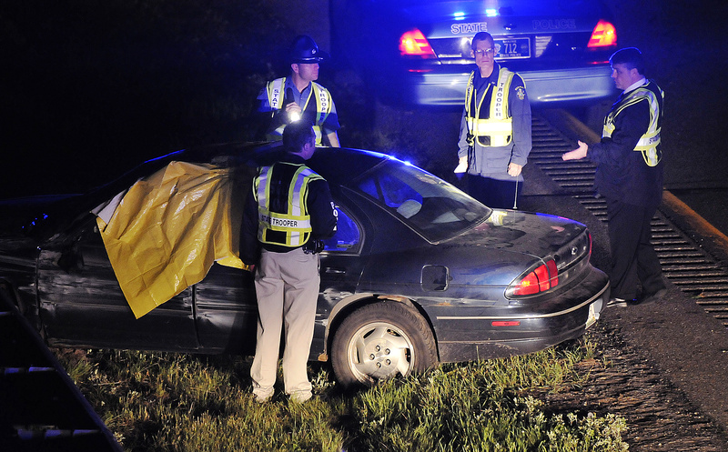 Maine State Police troopers investigate the scene of a crash just off Exit 63 on Interstate 95 late Monday night. Initial reports indicated that the driver killed himself after shooting and killing a Winslow woman and leading police on a chase.