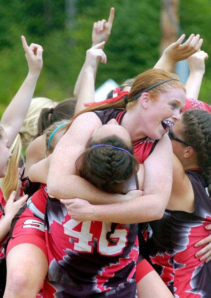 Scarbourough pitcher Maureen Hannan ,center, is hugs teammate Marisa O'Toole as the Red Storm their victory over the Messalonskee High School team after the last out of the Class A state championship softball game on today at Cony Family Field in Augusta. Scarborough blanked the Eagles 5-0.