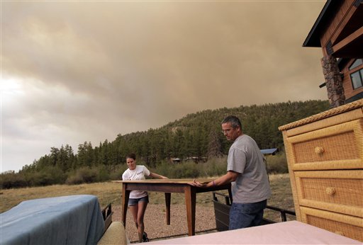 Jim Tress, right, and his daughter Samantha move furniture as they evacuate their home in Greer, Ariz., Saturday, June 4, 2011. Firefighters are working to contain the third largest fire in state history, with its smoke visible in parts of southern Colorado. Fire officials said they had zero containment of the fire near the New Mexico-Arizona state line, which has forced an unknown number of people to evacuate.