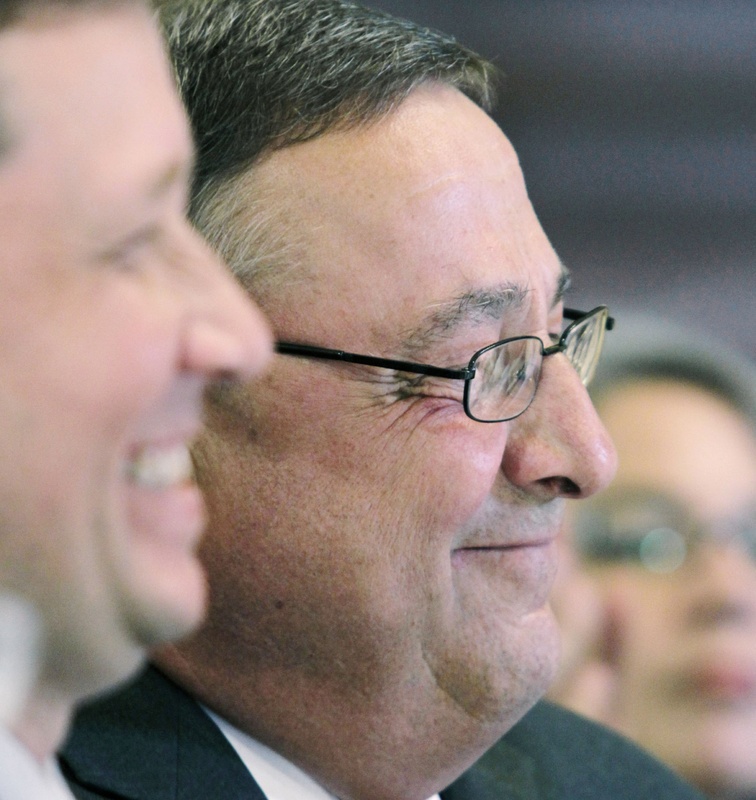 Gov. Paul LePage, right, smiles during a ceremony where he signed a bill authorizing charter schools at the State House on Wednesday. At left is Education Commissioner Stephen Bowen.