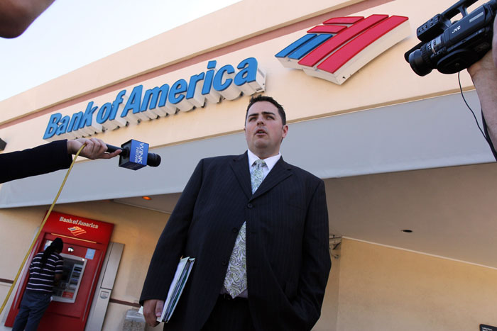 Todd Allen, attorney for Warren and Maureen Nyerges, speaks to the media outside a Bank of America branch in Naples, Fla., last week while deputies meet with the bank manager inside. Bank of America tried to foreclose on the Nyerges' fully-paid-for home last year, starting a legal battle with the couple, who had paid cash for the home in 2009.
