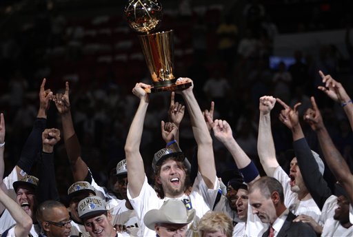 Dallas Mavericks' Dirk Nowitzki holds up the championship trophy after Game 6 of the NBA Finals basketball game against the Miami Heat Sunday in Miami. The Mavericks won 105-95 to win the series.