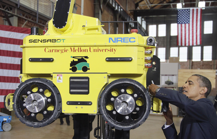 President Barack Obama signs a robot after speaking at Carnegie Mellon University in Pittsburgh today.